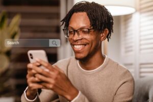 Homem usando smartphone para buscar por serviços de marketing digital em Sorocaba