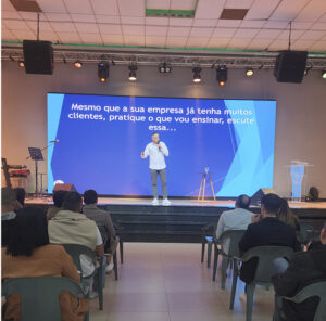 Anderson Dove palestrando em evento empresarial, ensinando estratégias de marketing digital, SEO e vendas no Google e Inteligência Artificial para empresas crescerem sem anúncios pagos."