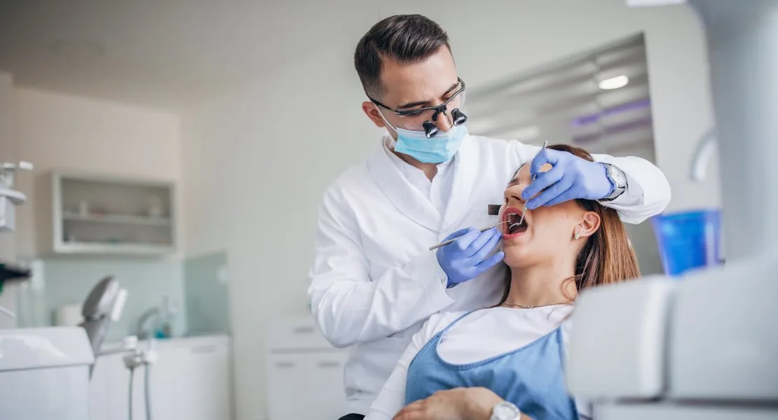 dentista realizando atendimento em paciente na cadeira odontológica