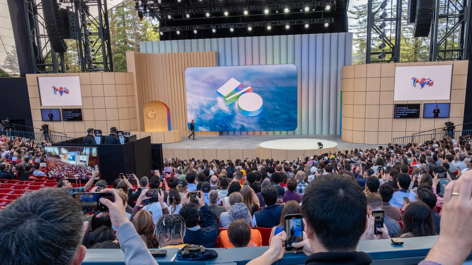 plateia lotada no Google IO 2026 com palco oficial e logo do evento projetado na tela principal