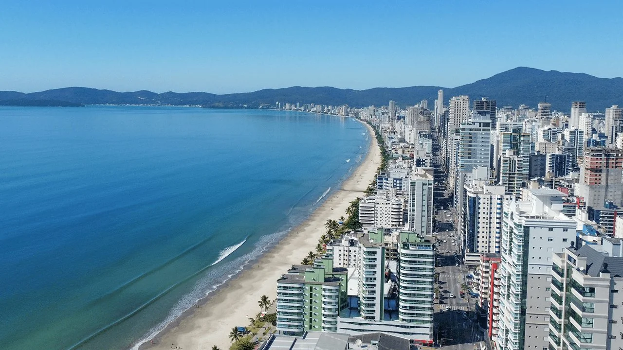 Vista aérea da orla de Meia Praia em Itapema SC com prédios, calçadão e mar