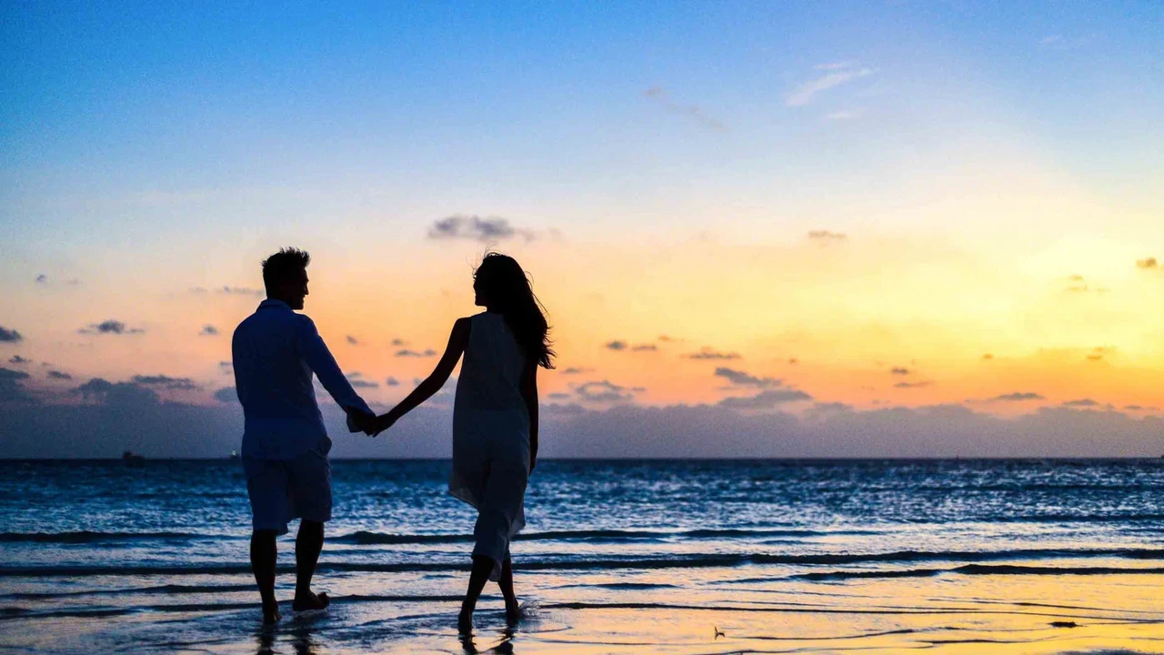 Casal de mãos dadas na praia ao pôr do sol em Itapema SC, Meia Praia, próximo ao Blue Sea Hotel
